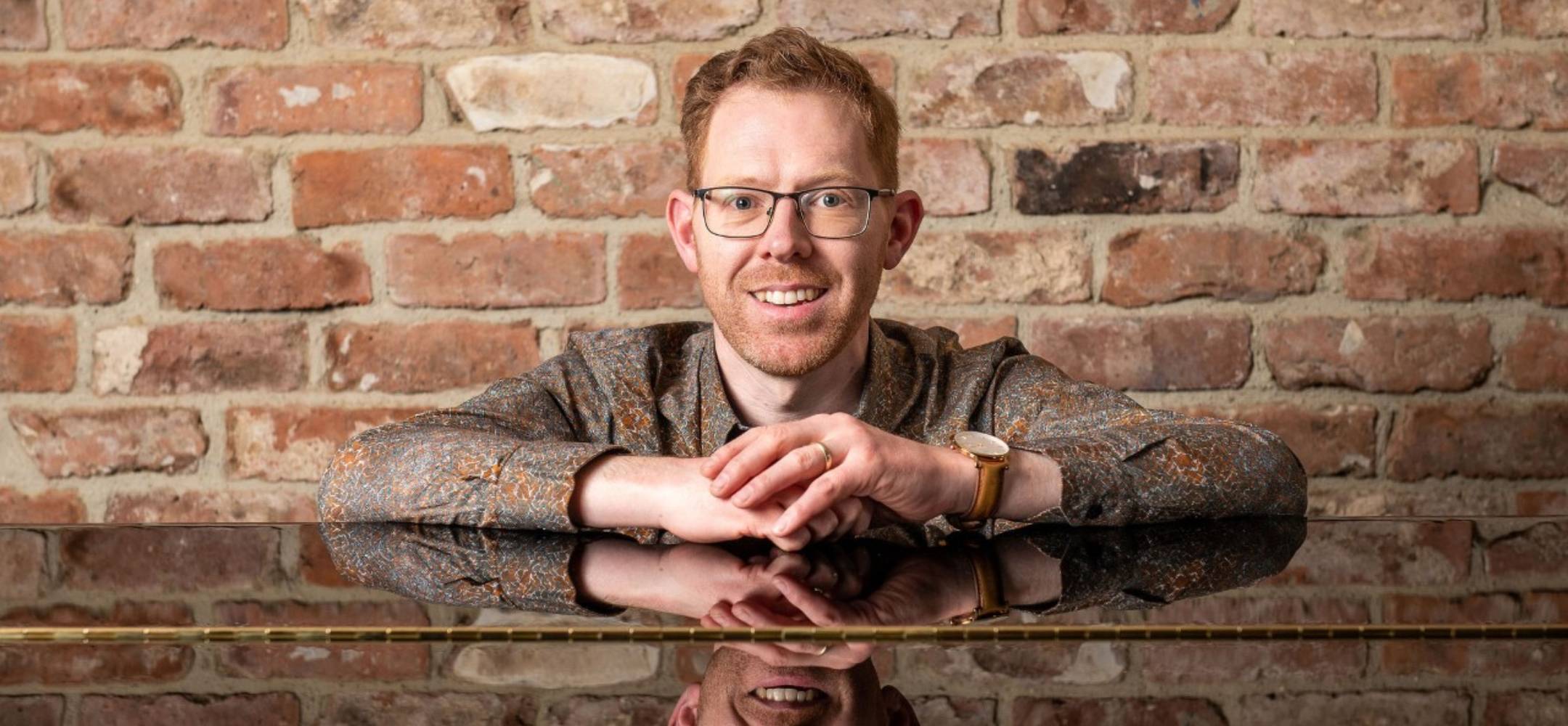 Jonathan Delbridge Leaning On Piano